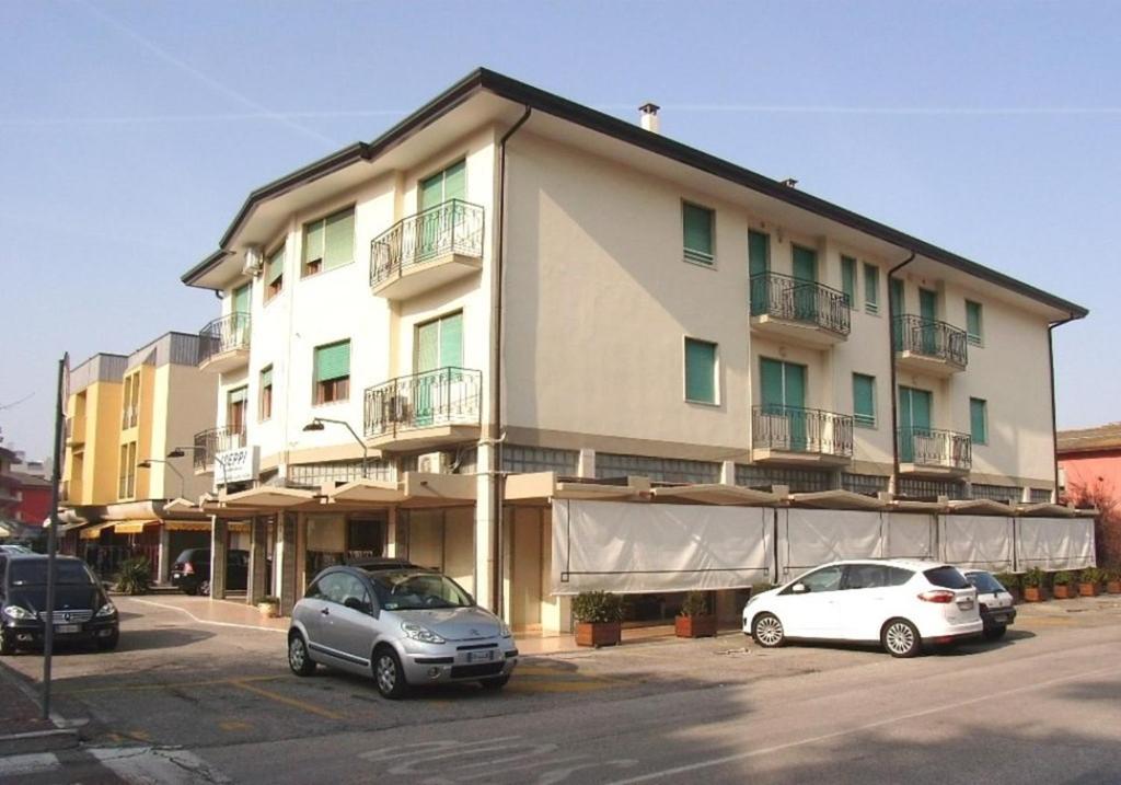 エラクレア・マーレにあるApartment in Eraclea Mare 25694の大きな建物の前に駐車した車両2台