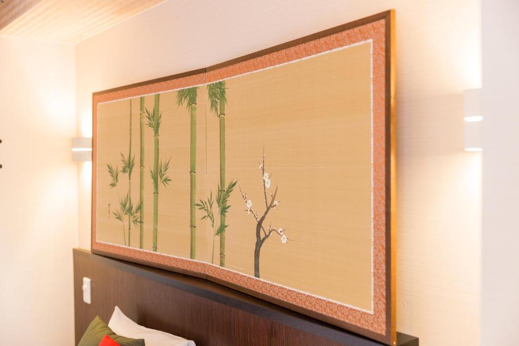 a large painting of palm trees on a wall at Kyoto Inn Gion The Second in Kyoto