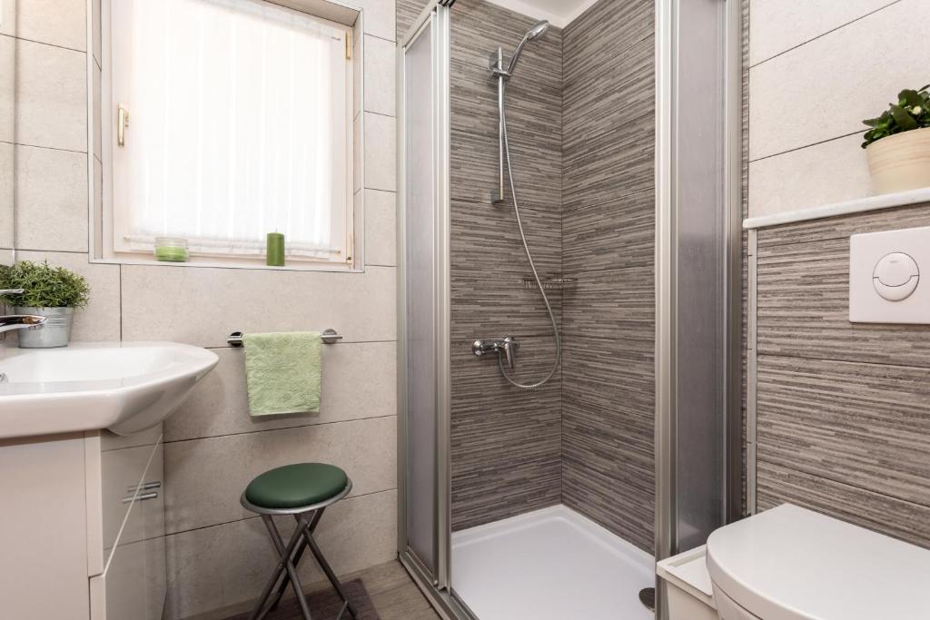 a bathroom with a shower and a toilet and a sink at Pansion Tina in Šilo