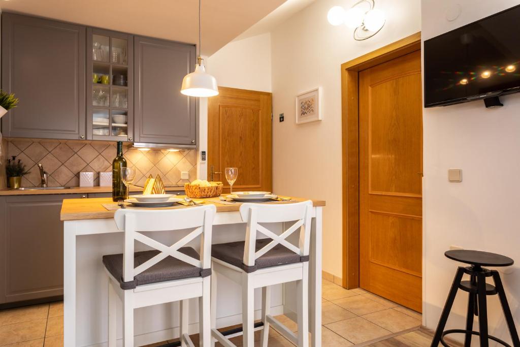 a kitchen with a white island with stools at Pansion Tina in Šilo