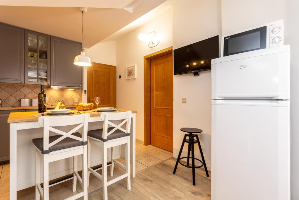 a kitchen with a white refrigerator and a counter at Pansion Tina in Šilo