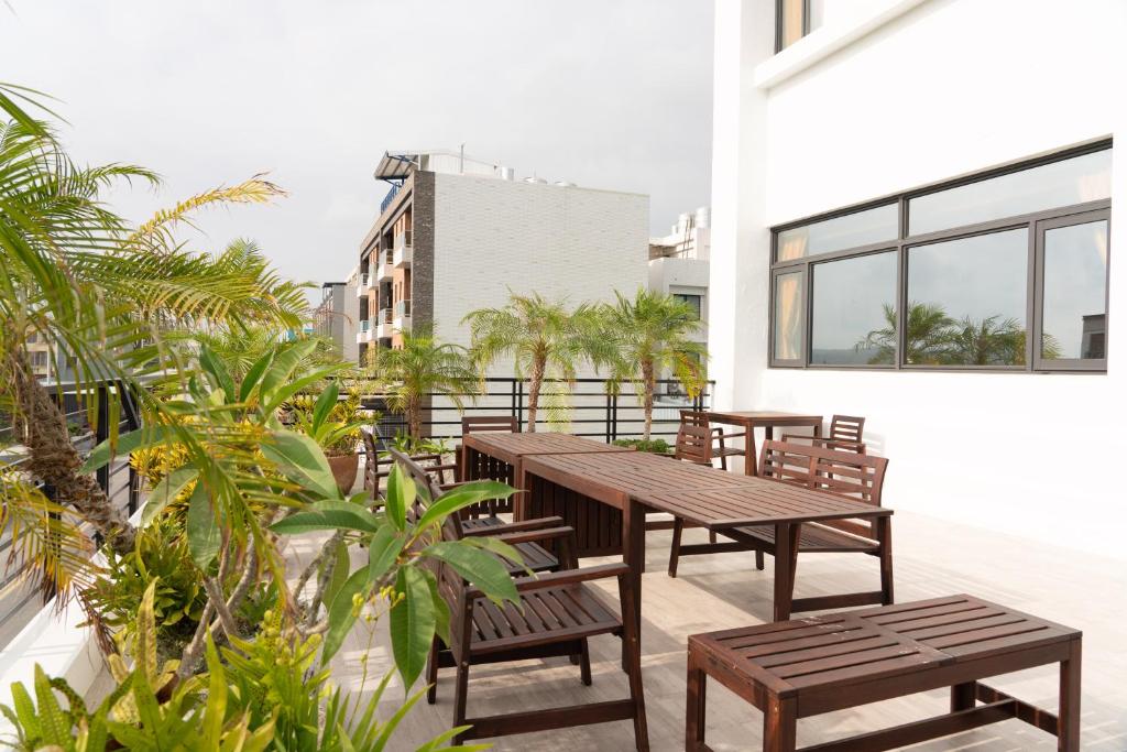 a balcony with wooden tables and benches and plants at HUA B&B in Hengchun South Gate