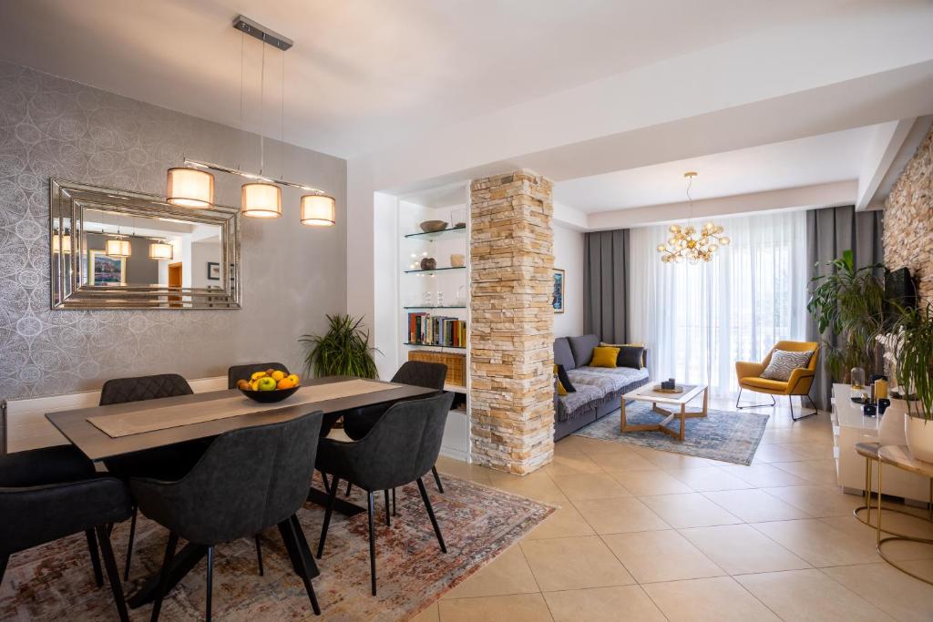 a dining room and living room with a table and chairs at Pansion Tina in Šilo