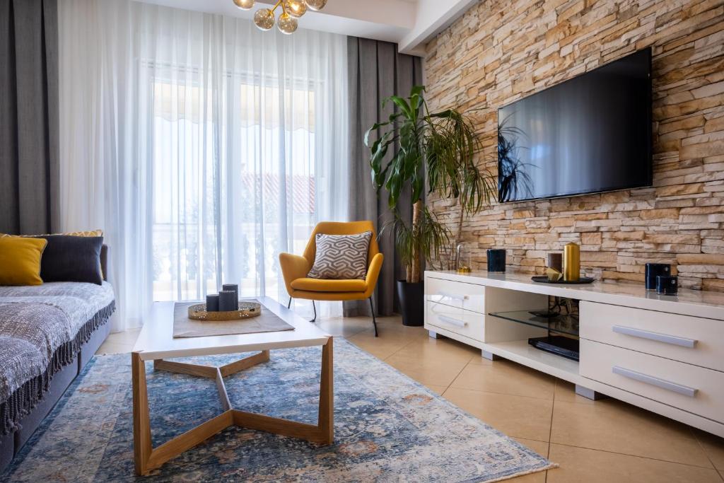 a living room with a couch and a tv on a brick wall at Pansion Tina in Šilo
