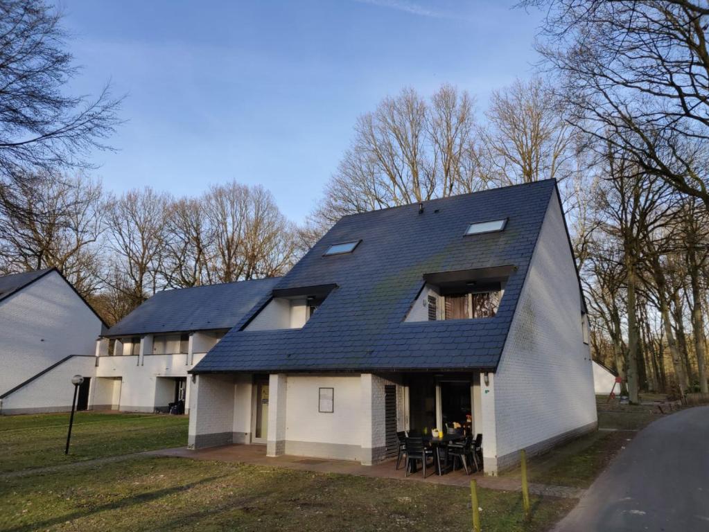 a house with a black roof on top of it at Acacia 1 Hengelhoef in Houthalen-Helchteren