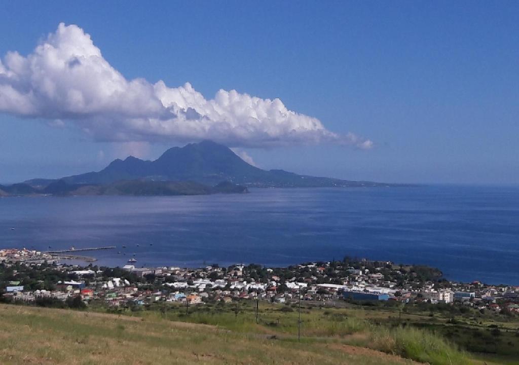 vistas a la ciudad y al océano con una montaña en Beacon Rise Apartment en Basseterre