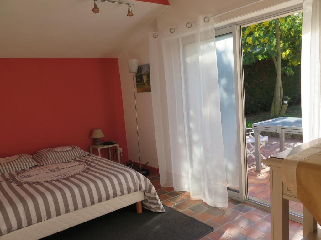 a bedroom with a bed and a sliding glass door at chez Annick in La Flèche