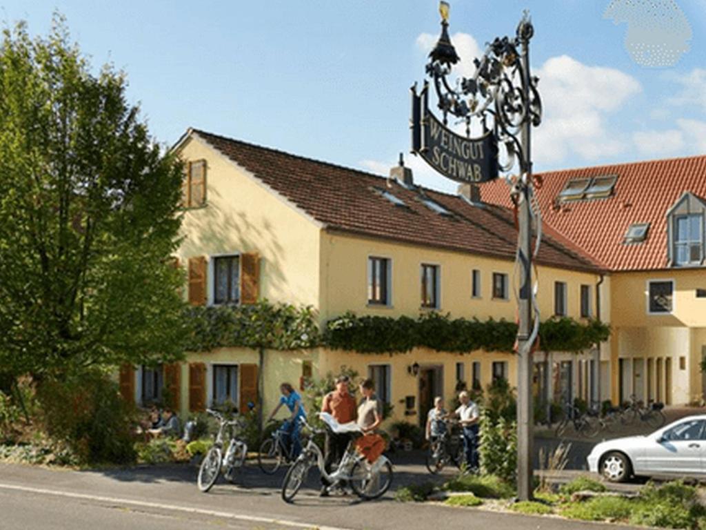 un grupo de personas montando bicicletas delante de un edificio en Pension Weingut Schwab en Thüngersheim