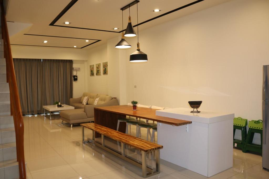 een keuken en een woonkamer met een tafel en een bank bij Lan Feng Su B&B in Yilan