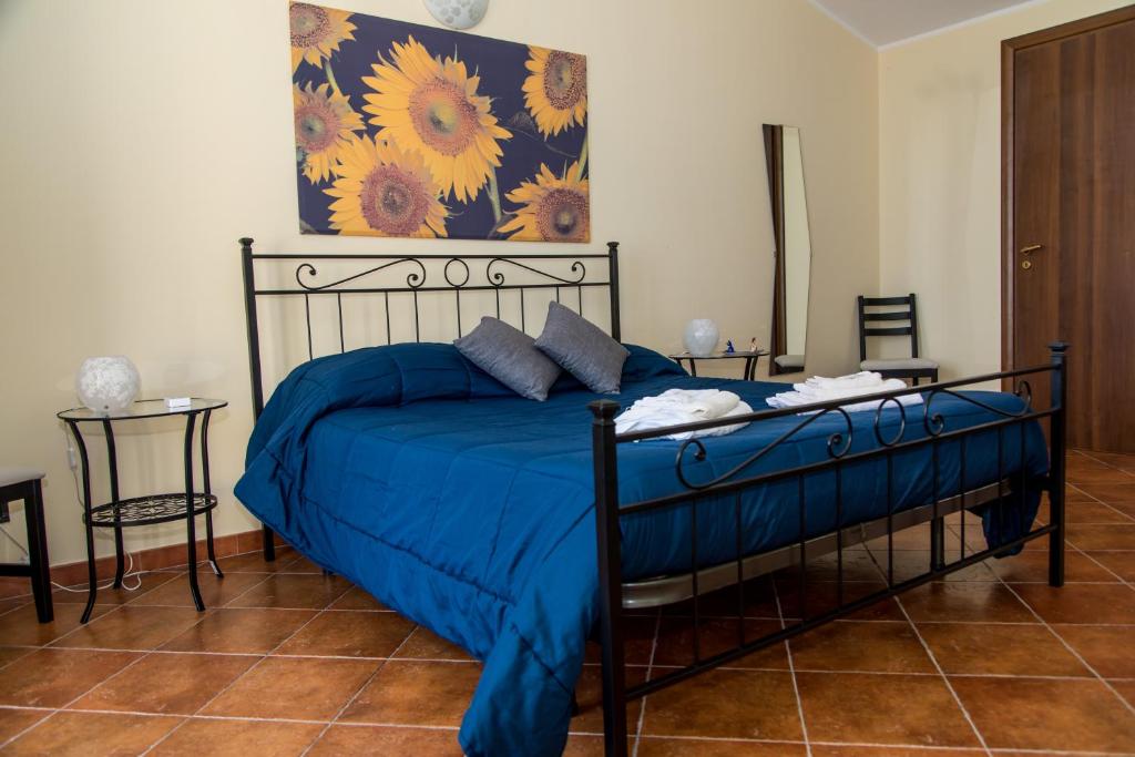 Schlafzimmer mit einem Bett mit blauer Decke in der Unterkunft Gli Ulivi Dell'Etna in Linera