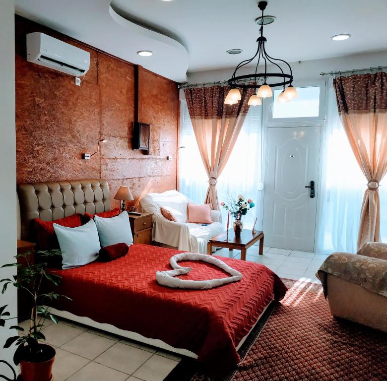 - une chambre avec un lit doté d'un couvre-lit rouge dans l'établissement Sweet Home Suite, à Corinthe