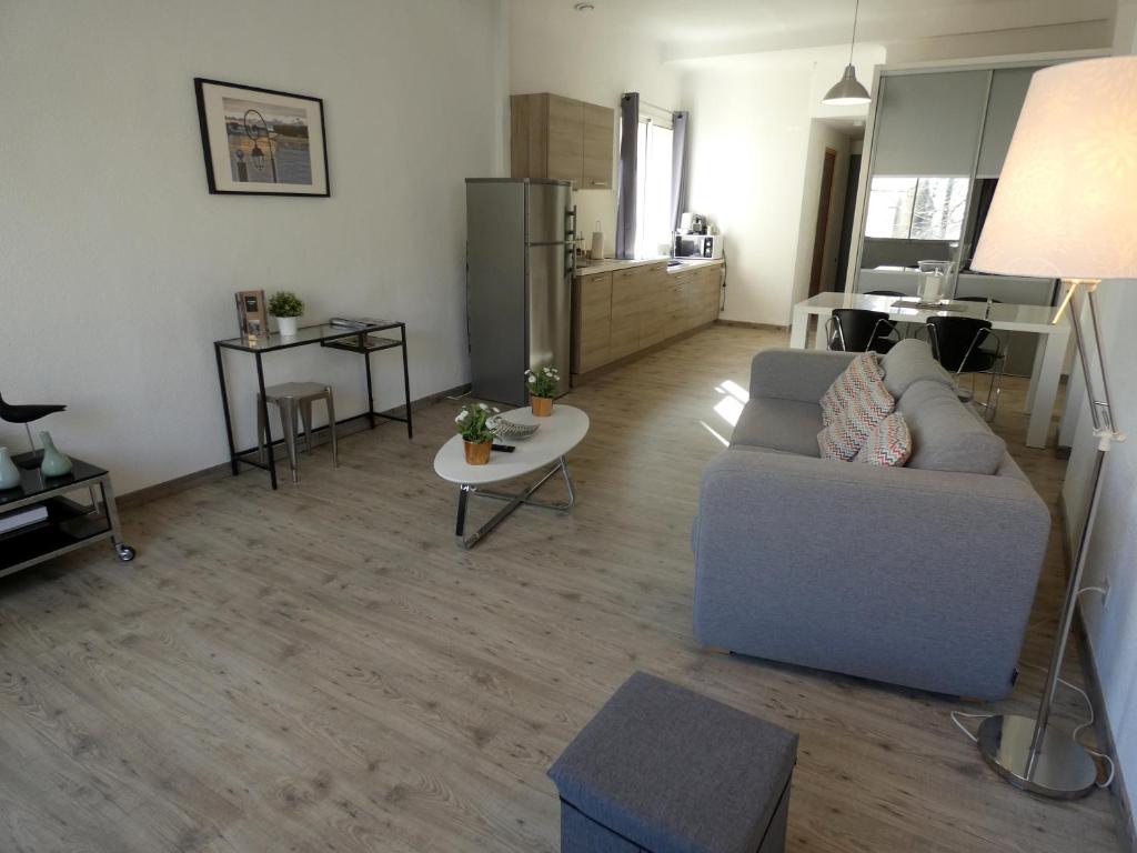 a living room with a couch and a table at Arles Forum - Les Pénitents Bleus in Arles