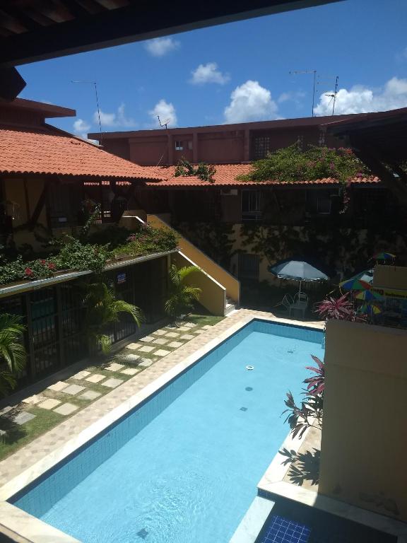 a swimming pool in front of a building at Reserva dos Corais in Cabo de Santo Agostinho