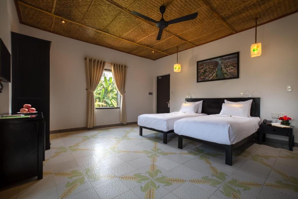 Postel nebo postele na pokoji v ubytování Hoi An Corn Riverside Villa