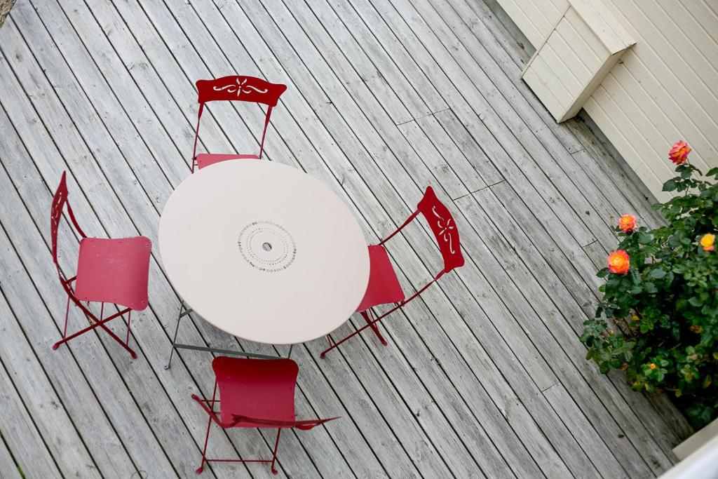an overhead view of a white table and red chairs at Les Costils in Saint-Laurent-sur-Mer