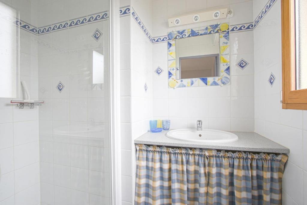 a bathroom with a sink and a shower at Les Costils in Saint-Laurent-sur-Mer