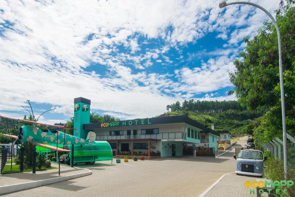 a building with a water slide in a parking lot at EcoMAPP Hotel in Aparecida