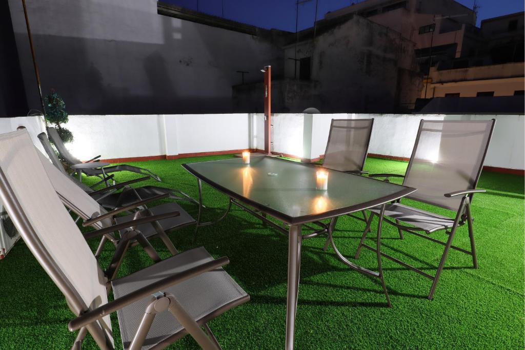 una mesa de cristal y sillas en un campo de hierba en La Terraza de Alfaros & Parking Gratuito en Córdoba