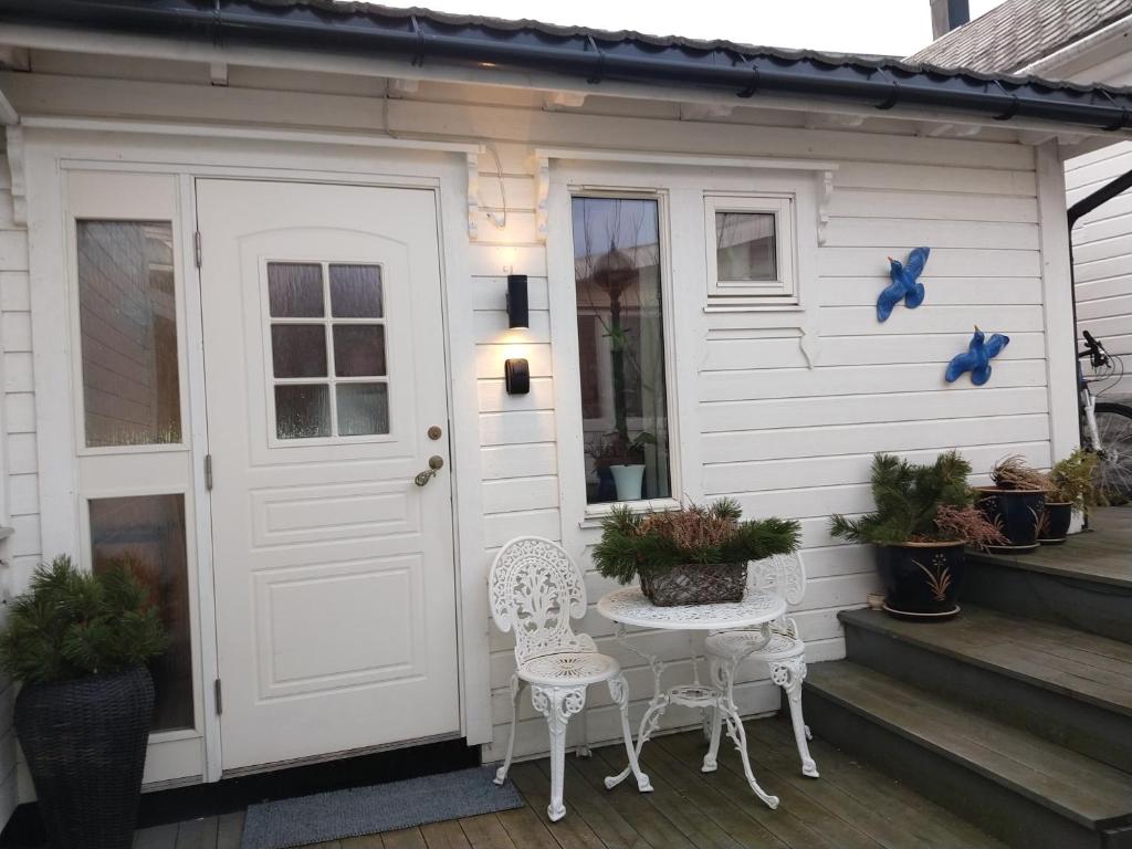 uma casa branca com duas cadeiras e uma porta em Huset på hauen em Volda