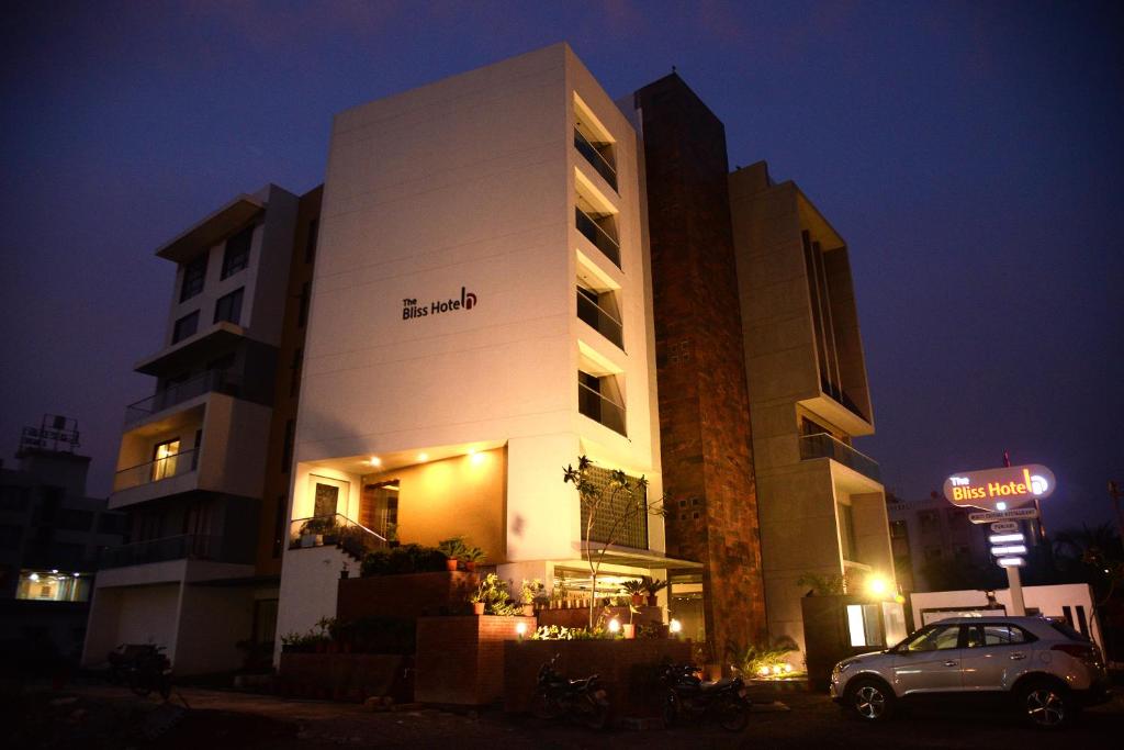 een gebouw waar een auto voor geparkeerd staat bij The Bliss Hotel in Somnath