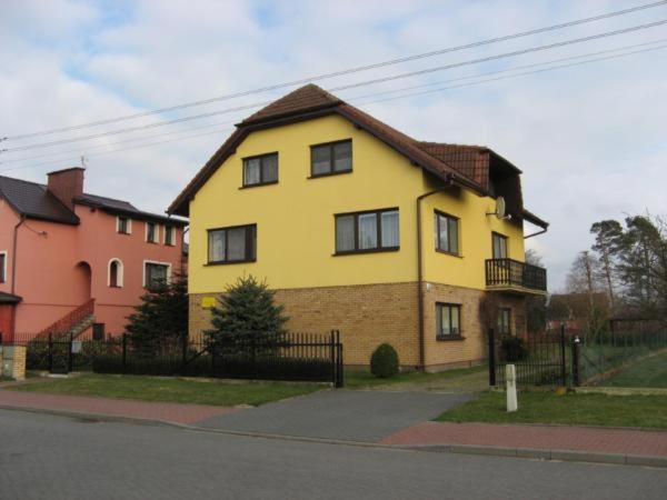 a yellow house on the side of a street at Dom Colonia in Żarnowska