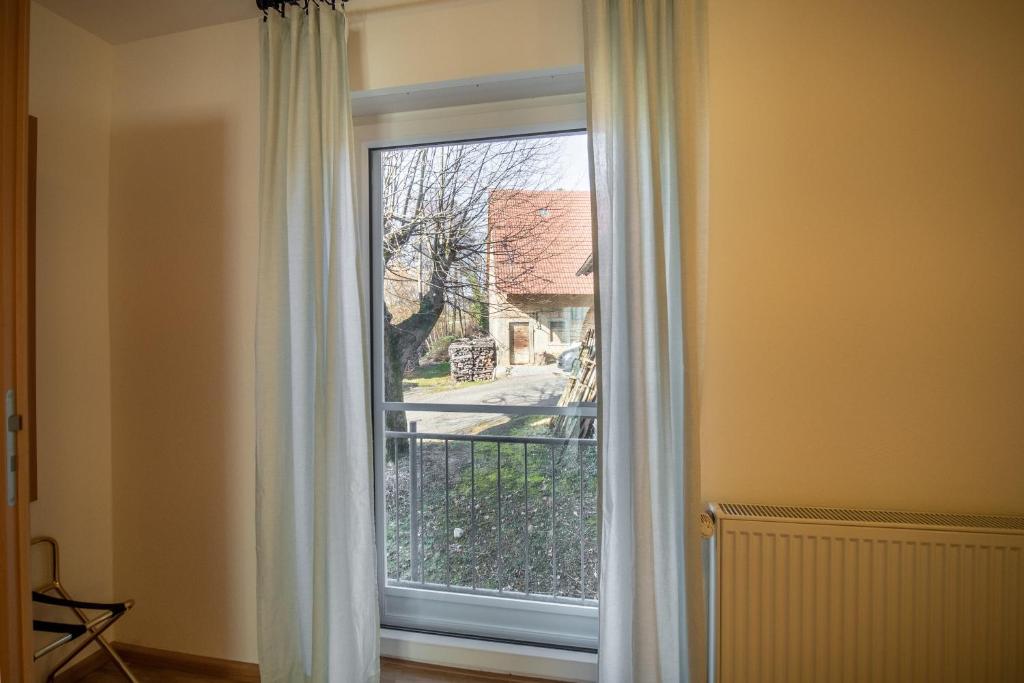 a window with white curtains in a room at Haus am Blauenbach in Schliengen