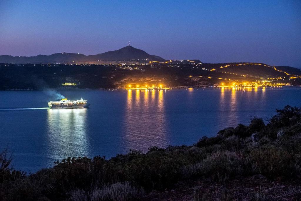 a boat on a large lake at night at Margarita Apt - Amazing Relaxing View in Megála Khoráfia