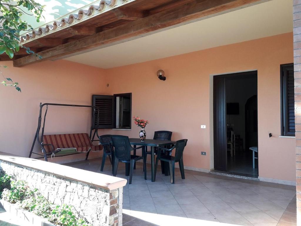 una casa con patio con mesa y sillas en Casa Deledda, en La Caletta