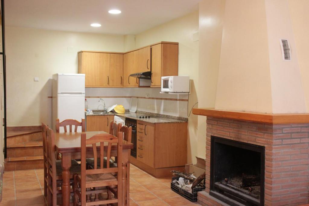 a kitchen with a fireplace and a table and chairs at Casa Mercedes in Molinicos