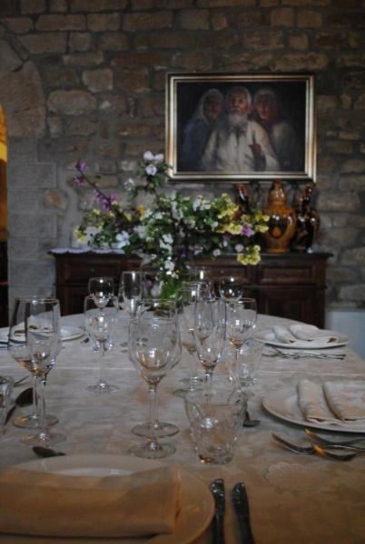 stół z kieliszkami do wina i kwiatami w obiekcie Agriturismo Castello Di San Vittorino w mieście Gubbio