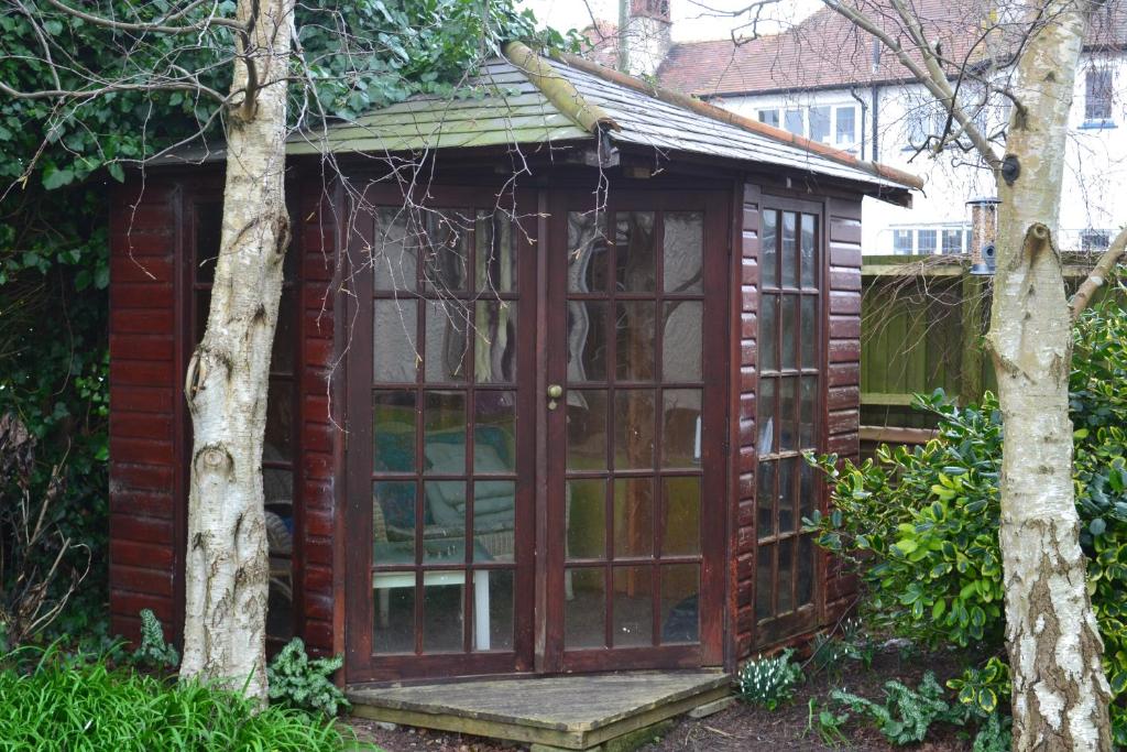 a garden shed with a large glass door at Sunnycroft in Sutton on Sea