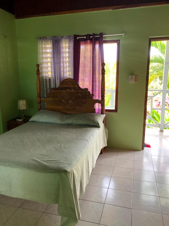 a bedroom with a bed in a room with a window at Seascape Apartments in Negril