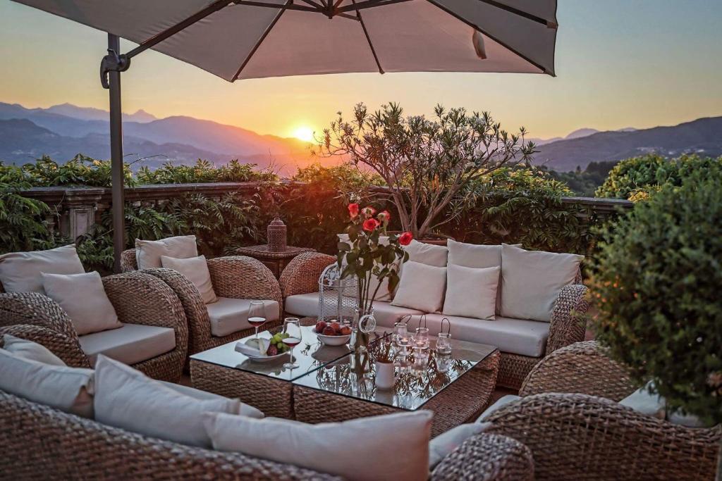a patio with a table and chairs and an umbrella at Villa Colletto in Coreglia Antelminelli