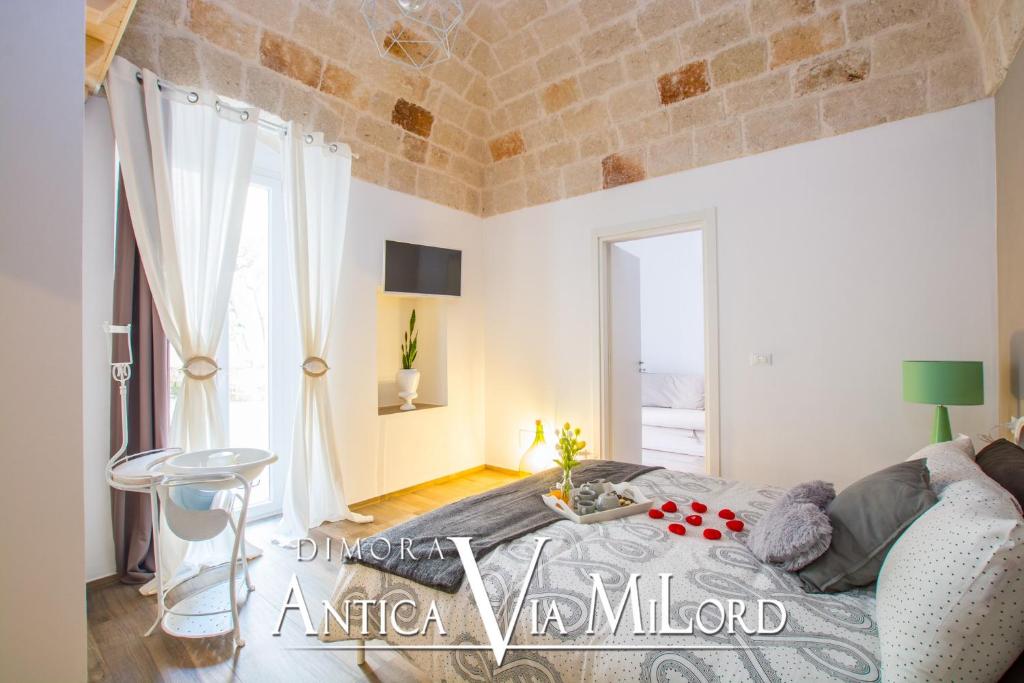 a bedroom with a bed and a large window at Dimora Antica Via MiLord in Monopoli