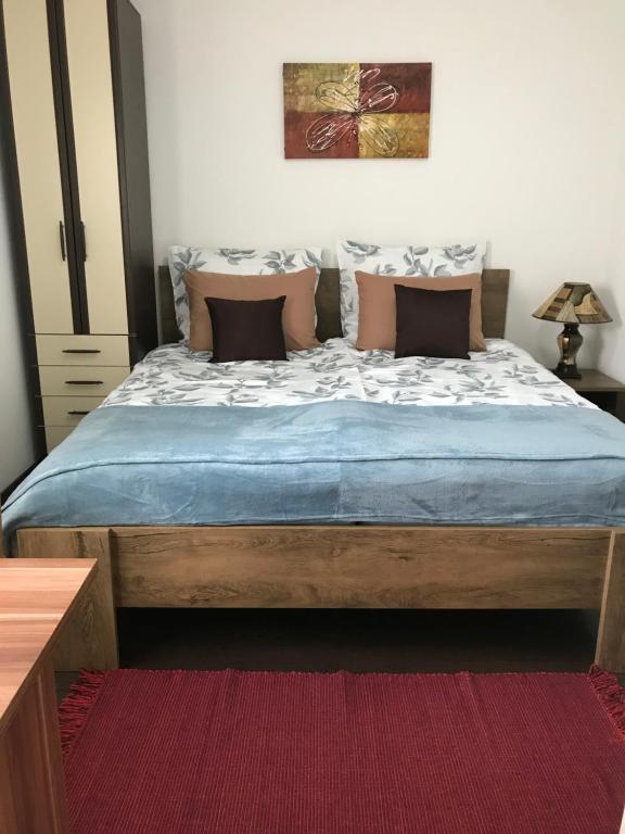 1 dormitorio con 1 cama con sábanas y almohadas azules en Sweet Garden, en Vogošća