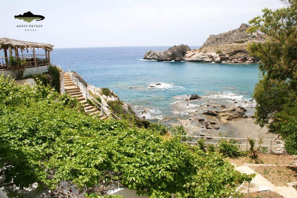 a stairway leading down to a beach with the ocean at Agios Pavlos Hotel in Agios Pavlos