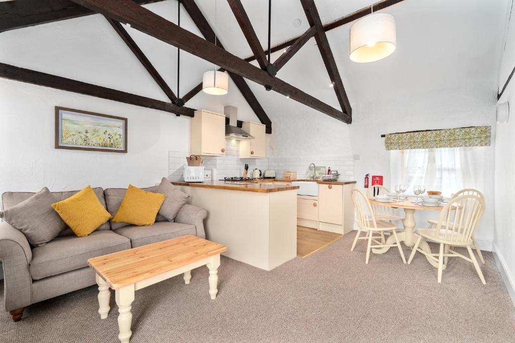 ein Wohnzimmer mit einem Sofa und einem Tisch in der Unterkunft Mill Cottage in Paignton