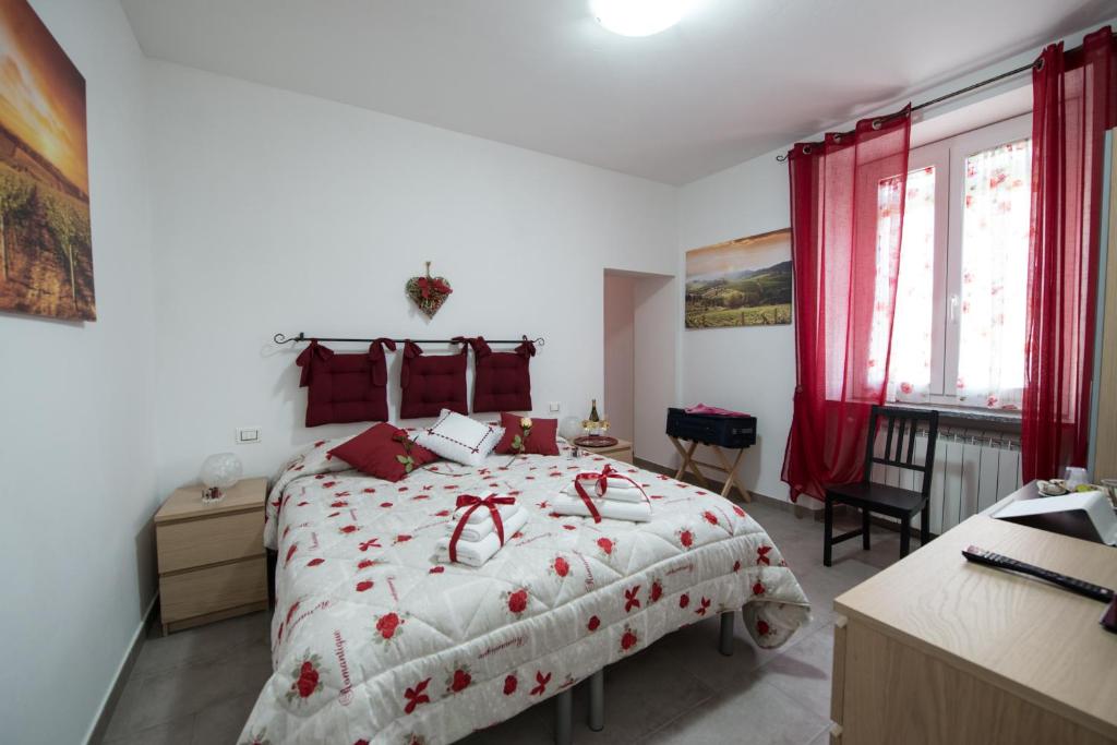 una camera da letto con un grande letto con accenti rossi di Il grappolo -affittacamere- a Gavi