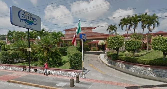 znak dla hotelu na ulicy z palmami w obiekcie Motel Caribe w mieście Kordoba