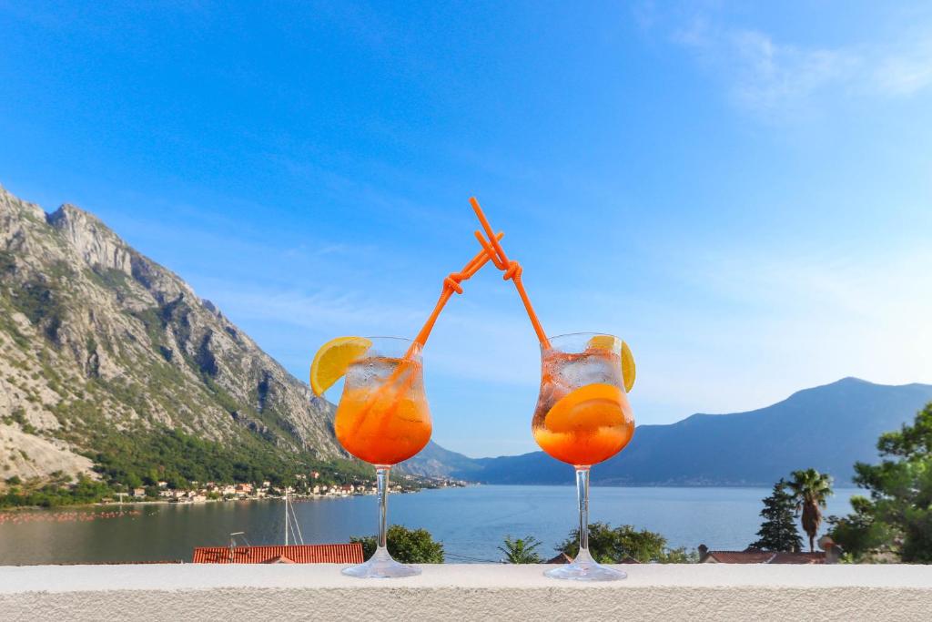 two glasses of orange juice with a view of the water at Sea Star Luxury Apartment in Kotor