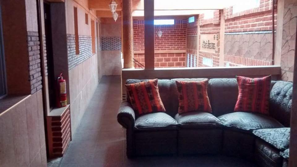 un sofá sentado en una habitación con almohadas en Departamentos Mis Viejos Queridos en Salta