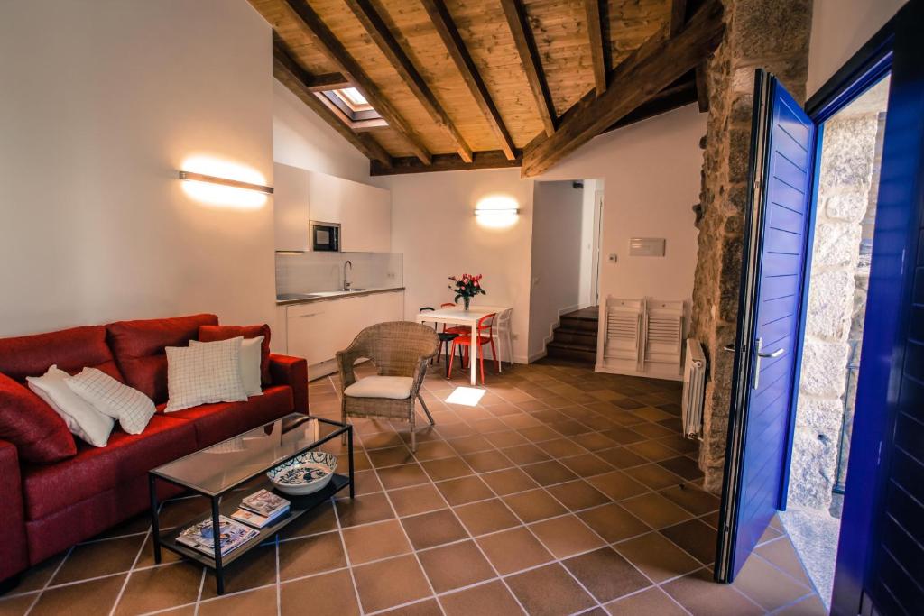 a living room with a red couch and a table at Apartamentos Ribeira Sacra in Parada del Sil