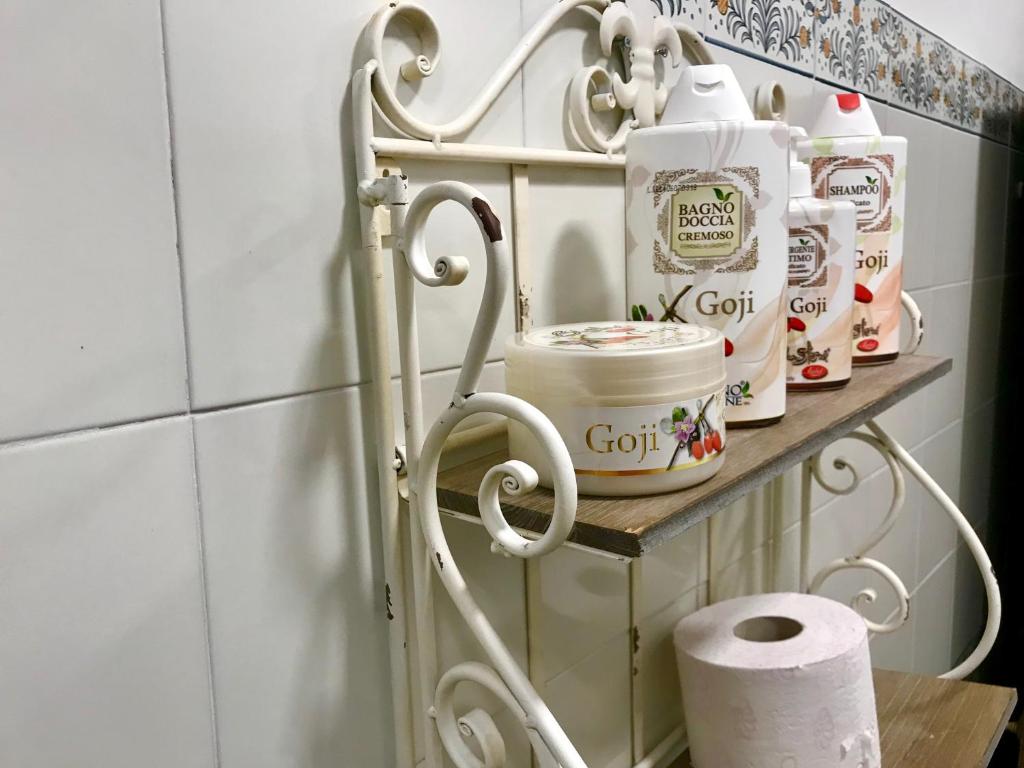 a towel rack with toilet paper and cups on it at Strange Uncle B&B in Florence