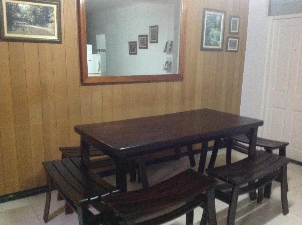 a dining room table with benches and a mirror at Mitchell's Guest House in DʼArbeau