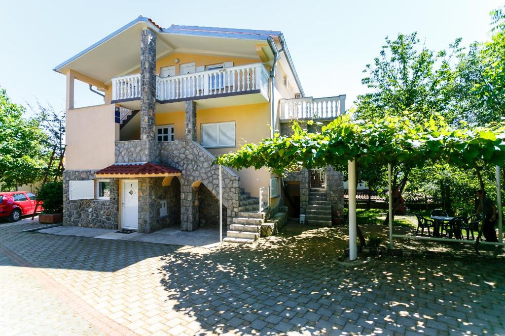 a house with a balcony on top of it at Apartments Posavec in Pinezici