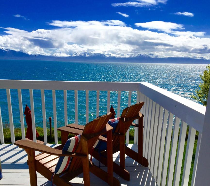 een terras met twee stoelen en een tafel op de oceaan bij Oceanhouse in Homer