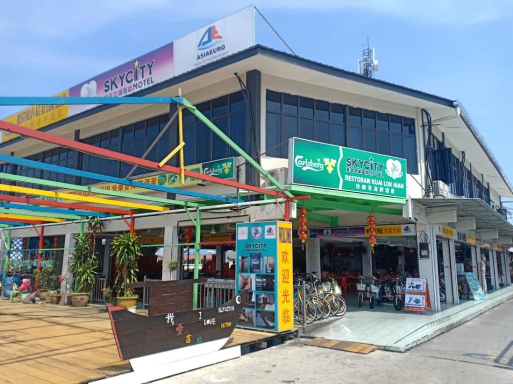 a building with a gas station in front of it at SkyCity Motel Pulau Ketam in Bagan Teochew