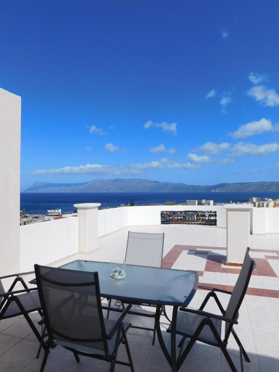 taras ze stołem i krzesłami na dachu w obiekcie Panoramic Balos Sea View House w mieście Kisamos