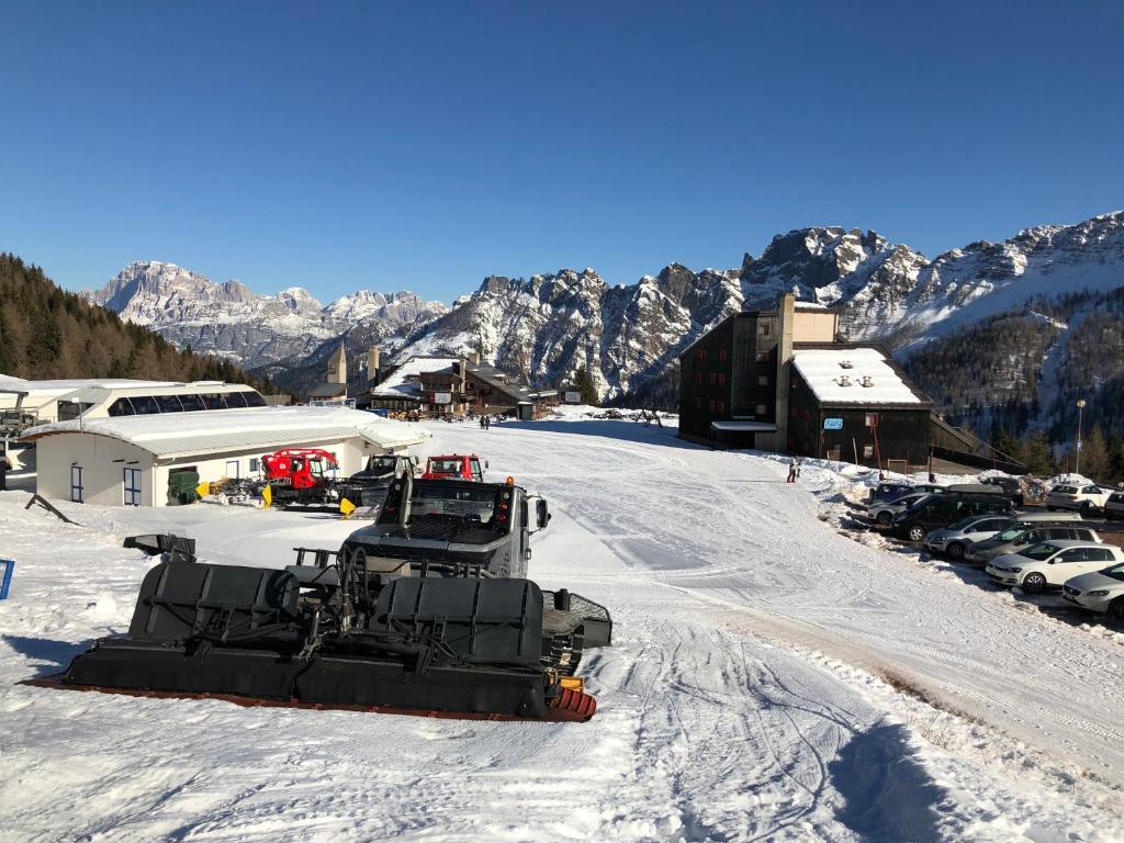 un chasse-neige est garé sur une montagne enneigée dans l'établissement Piccolo Nido Falcade, à Falcade