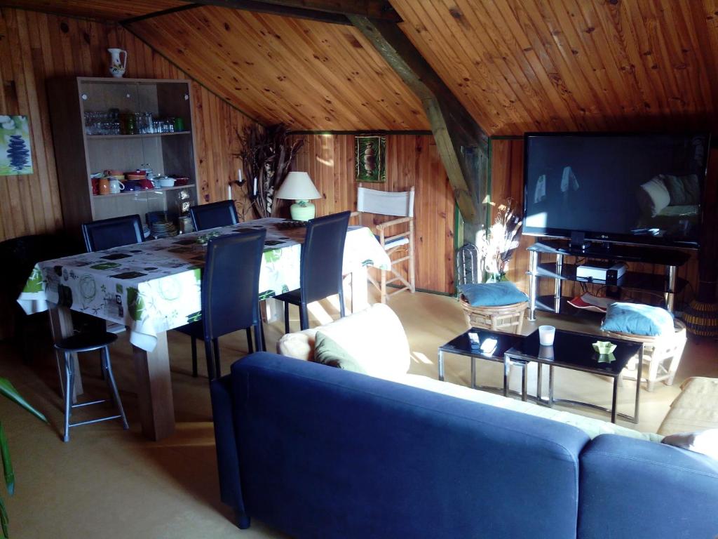 - un salon avec une table et un canapé bleu dans l'établissement appartement 1er étage dans maison individuelle, à Tanavelle